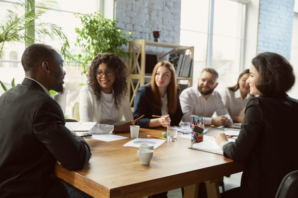 Happy emotions. Group of young business professionals having a meeting. Diverse group of coworkers discuss new decisions, plans, results, strategy. Creativity, workplace, business, finance, teamwork.