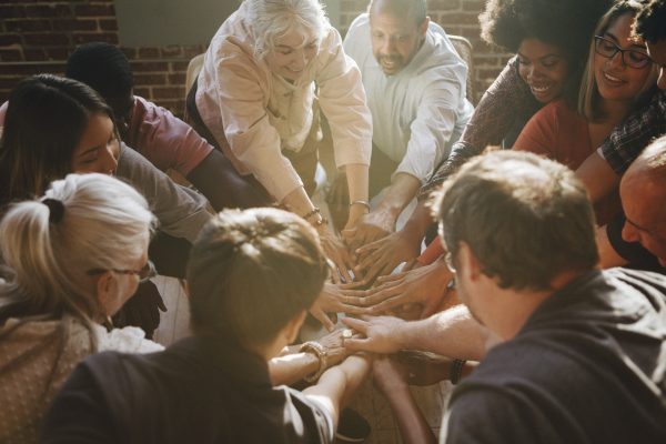 Group of diverse people stacking hands in the middle